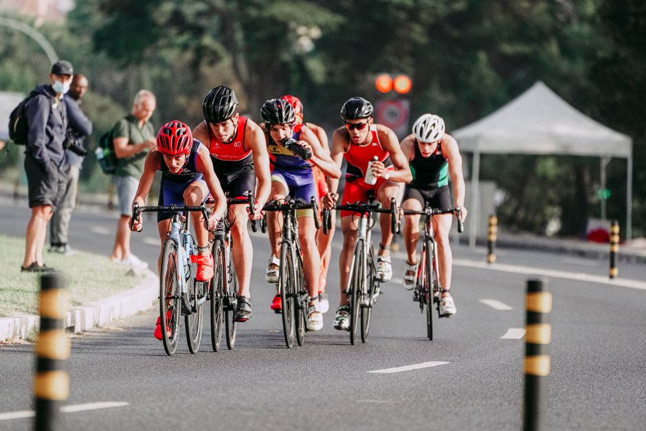 Full body of strong cyclists in professional sportswear riding bicycles while taking part in race
